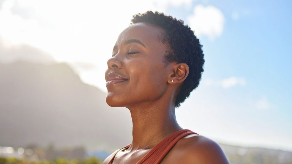 Smiling Black woman in her 40s embracing hormone-supportive lifestyle changes